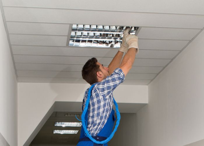 Worker installing a ceiling light